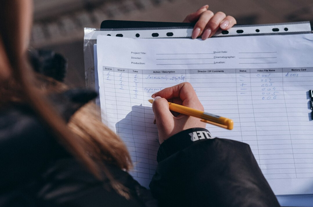 person writing budget on paper