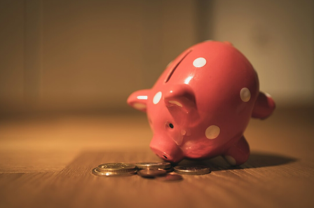 child saving coins in piggy bank